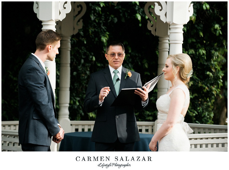 officiant marries a bride and groom in front of a gazebo