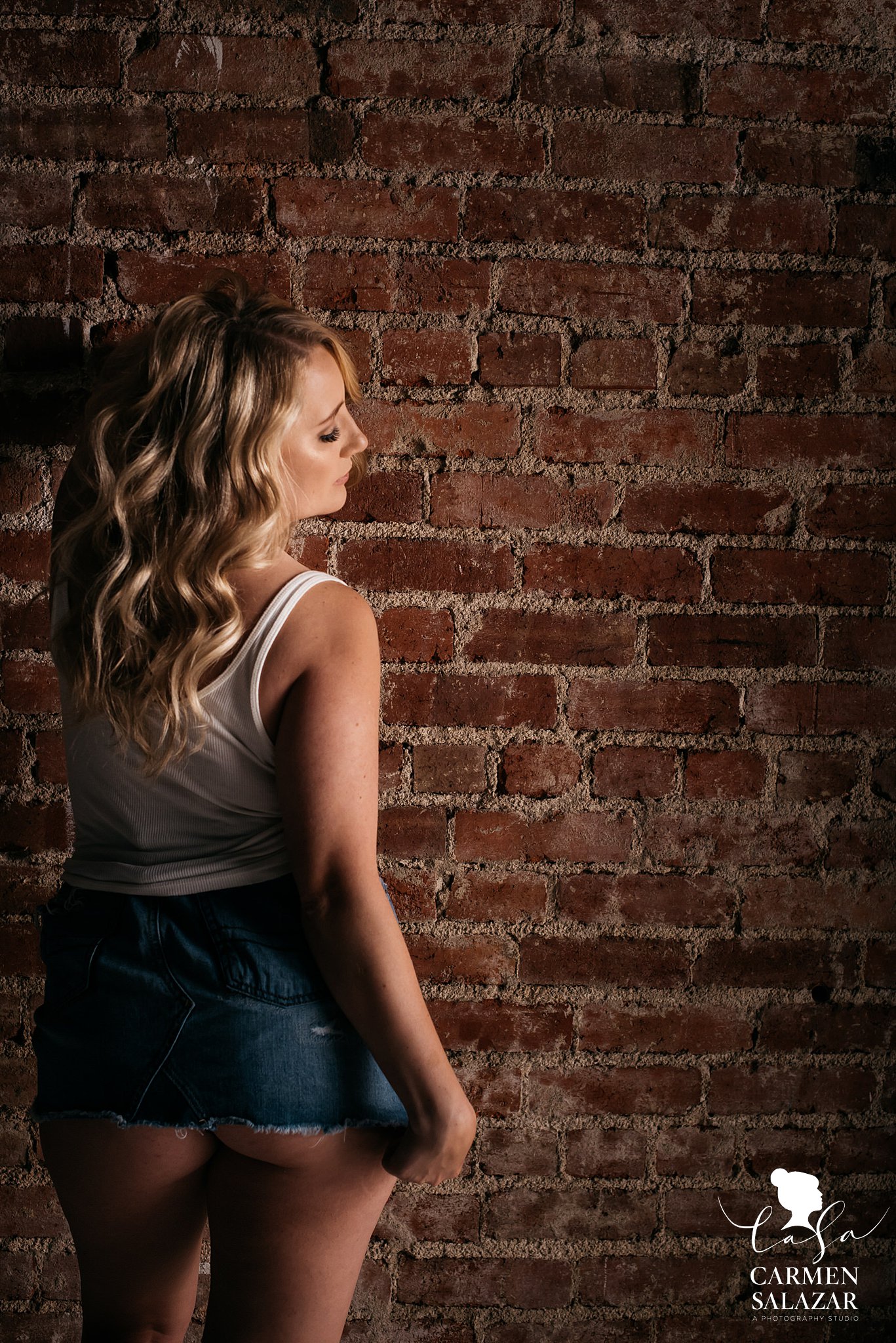 Sacramento Bridal Boudoir by Carmen Salazar teasing boudoir pose with girl in denim skirt